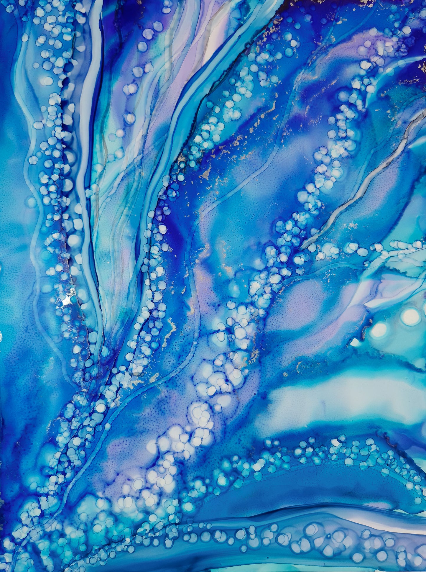 Ocean-inspired fluid art featuring swirling shades of blue, delicate white bubbles, and shimmering accents.